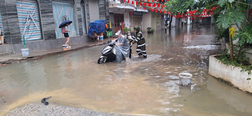 Công an phường Ba Đình hỗ trợ người dân đưa phương tiện qua phố ngập úng