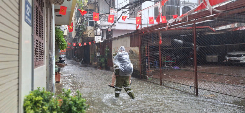 Chiến sỹ Công an phường Ba Đình cõng người già ốm bệnh giữa phố ngập