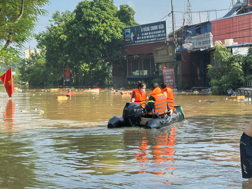 Hỗ trợ đưa người dân trong vùng ngập lụt đến nơi an toàn