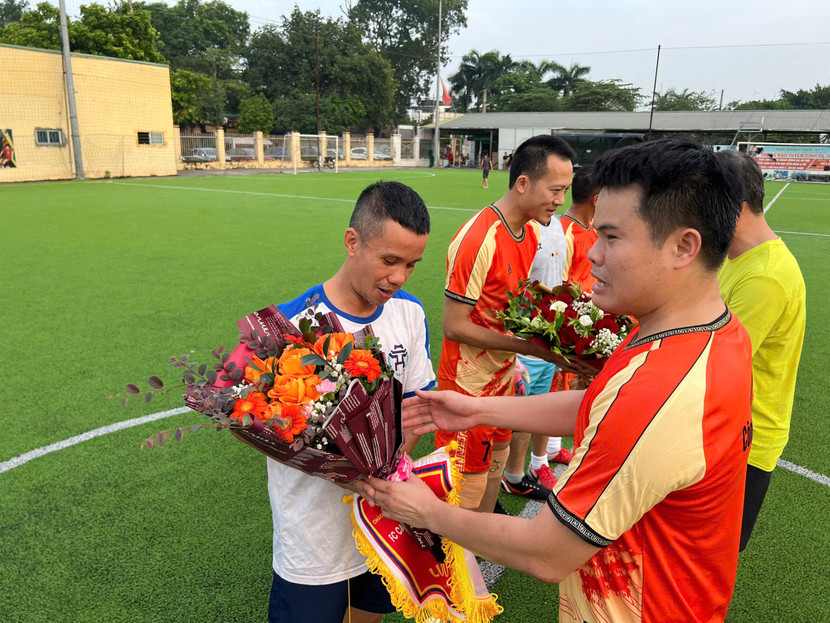 Trung tá Hán Minh Kiên, Trưởng Công an phường Kiến Hưng tặng hoa Đội trưởng CLB Phóng viên FC Thăng Long