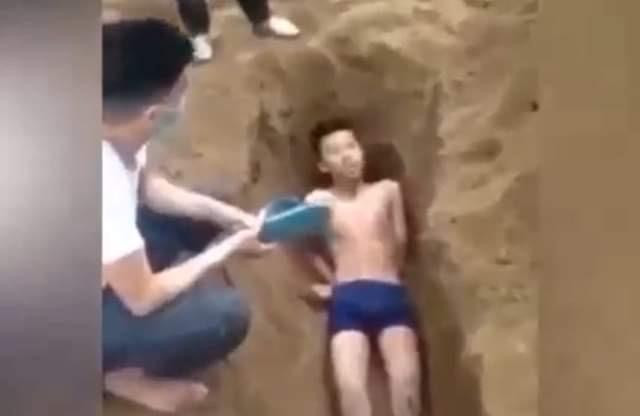 Hình ảnh nam thanh niên bị đẩy vào hố cát (ảnh cắt từ clip)