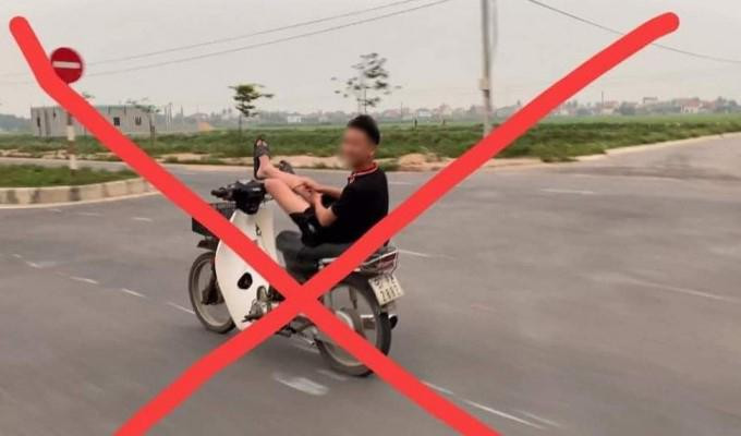 T dùng chân điều khiển xe máy chạy trên đường (ảnh cắt từ clip) T dùng chân điều khiển xe máy chạy trên đường (ảnh cắt từ clip)