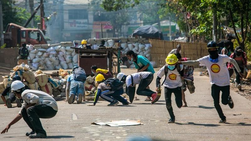 Người biểu tình bỏ chạy khi đối đầu với quân đội ở thành phố Yangon, Myanmar (Ảnh: AFP)