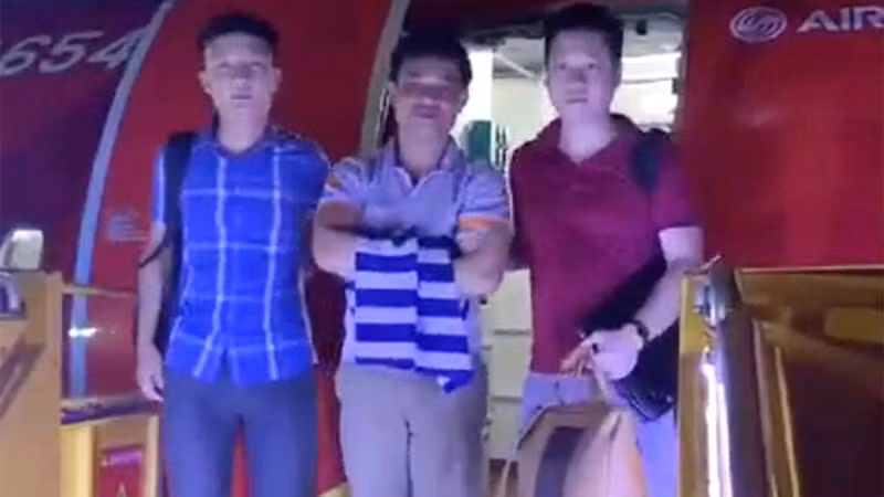 Bị can Sáng (giữa) lúc bị cảnh sát dẫn ra máy bay di lý về Hà Tĩnh. Ảnh: Hùng Lê