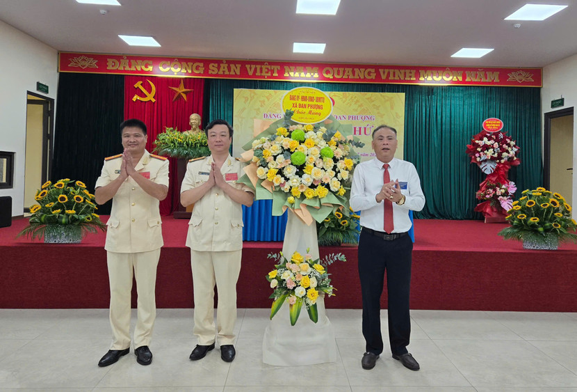 Ông Nguyễn Gia Hiển, Bí thư Đảng ủy, Chủ tịch HĐND xã Đan Phượng tặng hoa chúc mừng đại hội