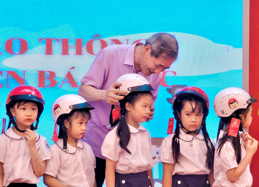 Bí thư Quận ủy Ba Đình Hoàng Minh Dũng Tiến trao tặng mũ bảo hiểm cho các em học sinh trường Tiểu học Nguyễn Bá Ngọc.