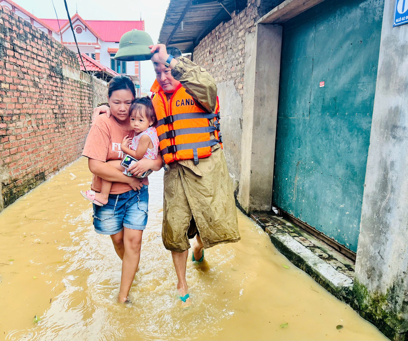 Lực lượng Công an xã Việt Long hỗ trợ giúp người dân thôn Tăng Long sơ tán khỏi vùng nguy hiểm