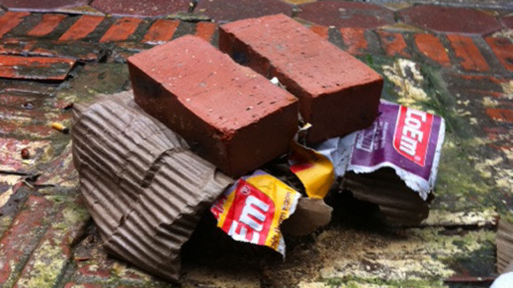 Ai đó đã che gốc sưa đỏ lại bằng bìa các-tông và gạch mộc