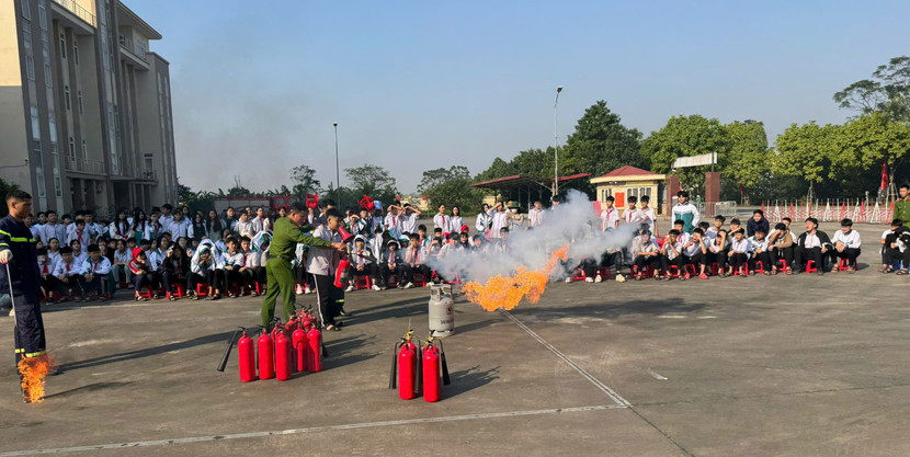 Các em học sinh thực hành sử dụng bình chữa cháy