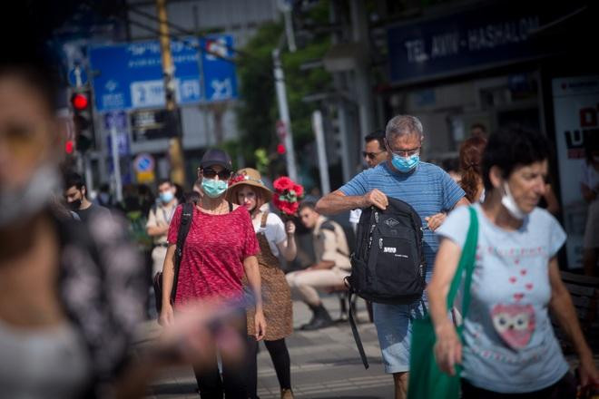 Người dân Israel đeo khẩu trang khi đi trên đường phố Tel Aviv hôm 22-7