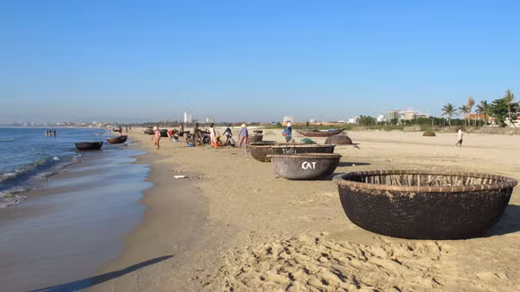 Chợ cá nhanh chóng "họp"... ...ngay ven biển Ở biển, mặt trời lên rất nhanh, mới chỉ 5h30 ánh nắng đã nắng chan hòa Một người đàn ông xách làn cá đi trong bình minh