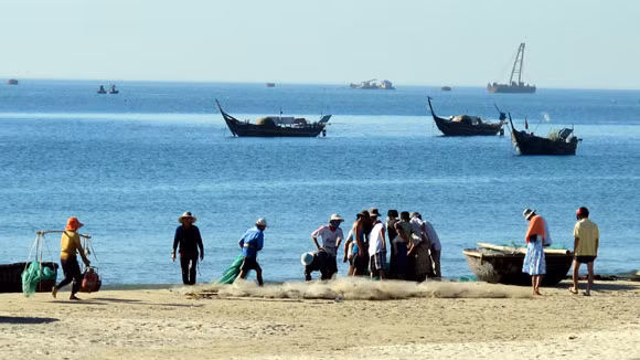 Chợ cá nhanh chóng "họp"... ...ngay ven biển Ở biển, mặt trời lên rất nhanh, mới chỉ 5h30 ánh nắng đã nắng chan hòa Một người đàn ông xách làn cá đi trong bình minh