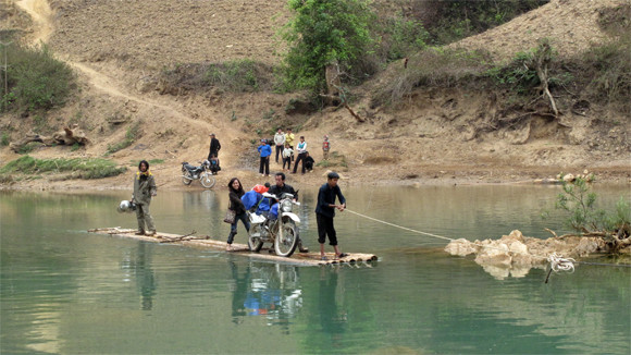 Khi xe máy gặp sự cố, phải nhờ người dân tộc kéo bè qua sông (Ảnh: Ngô Xuân Phú)