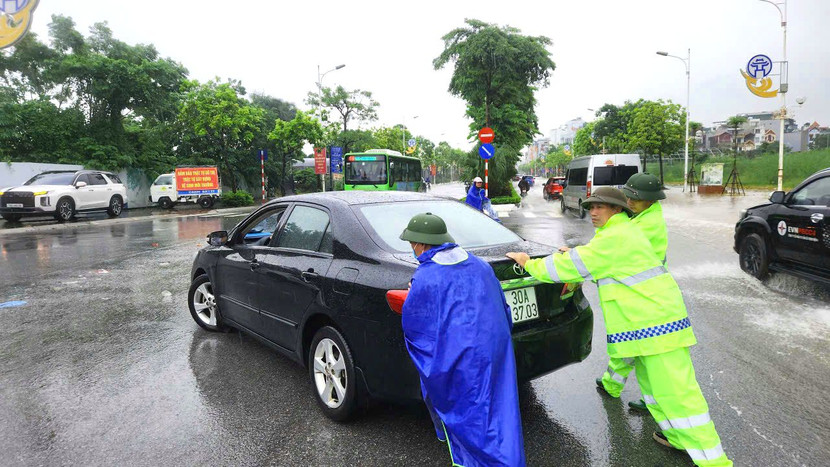 Cán bộ chiến sỹ CAP Long Biên hỗ trợ phương tiện qua điểm ngập trên đường Đàm Quang Trung