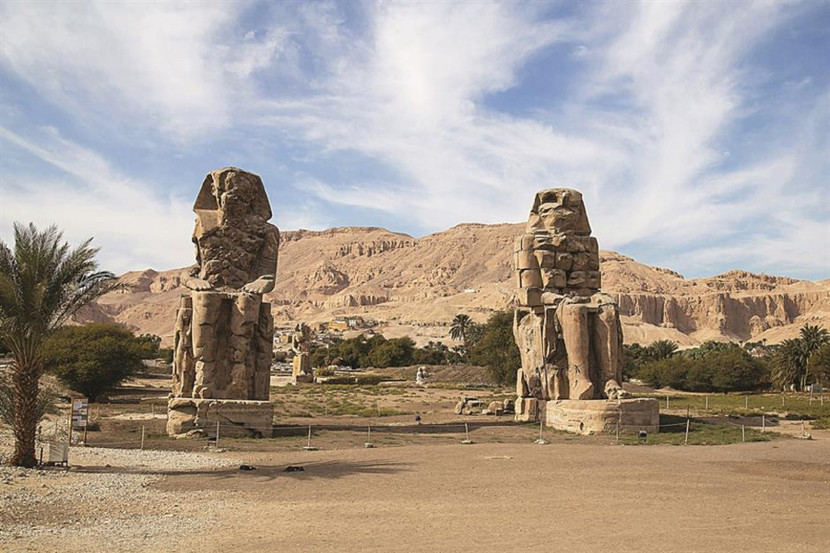 Những bức tượng của người anh hùng Ai Cập hư cấu Memnon cao 18m được xây dựng dưới thời Vua Amenhotep III (1390–1352 TCN). Những bức tượng của người anh hùng Ai Cập hư cấu Memnon cao 18m được xây dựng dưới thời Vua Amenhotep III (1390–1352 TCN).