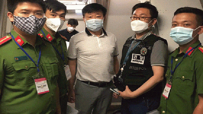 Đối tượng Shin Youngho (áo trắng) được bàn giao cho Cảnh sát Quốc gia Hàn Quốc (Ảnh: Dân Trí) Đối tượng Shin Youngho (áo trắng) được bàn giao cho Cảnh sát Quốc gia Hàn Quốc (Ảnh: Dân Trí)