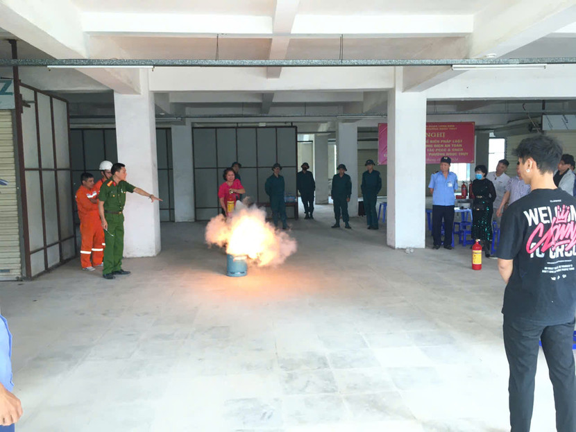 Công an quận Long Biên hướng dẫn tiểu thương thực hành sử dụng bình chữa cháy