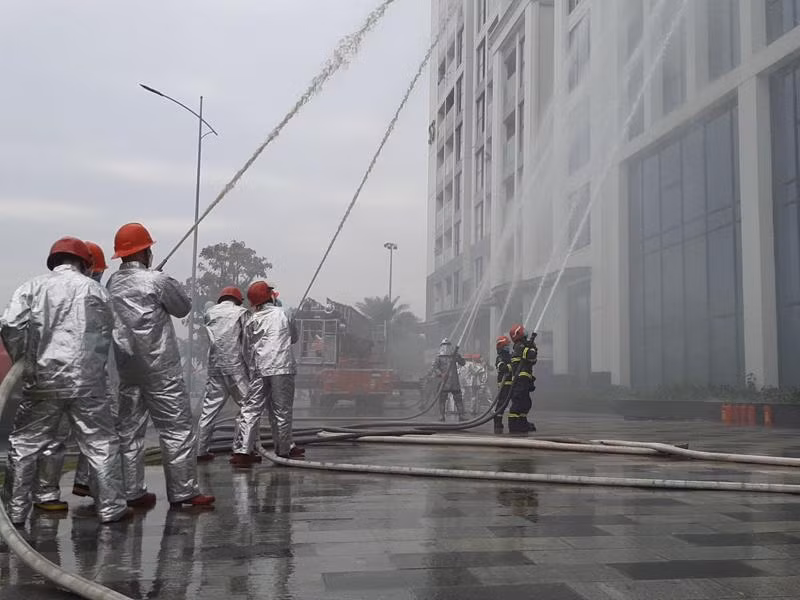 Các lực lượng nhanh chóng phối hợp xử lý sự cố cháy giả định tại buổi diễn tập phương án chữa cháy tổ hợp văn phòng - căn hộ chung cư Vinhomes Symphony