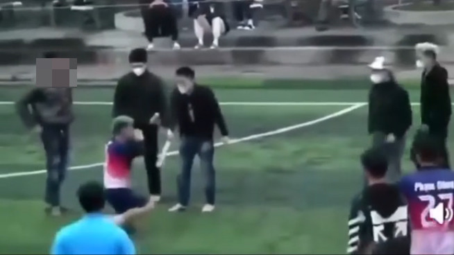 Hình ảnh các đối tượng bắt nam thanh niên mặc áo cầu thủ quỳ xuống sân bóng, được camera ghi lại Hình ảnh các đối tượng bắt nam thanh niên mặc áo cầu thủ quỳ xuống sân bóng, được camera ghi lại