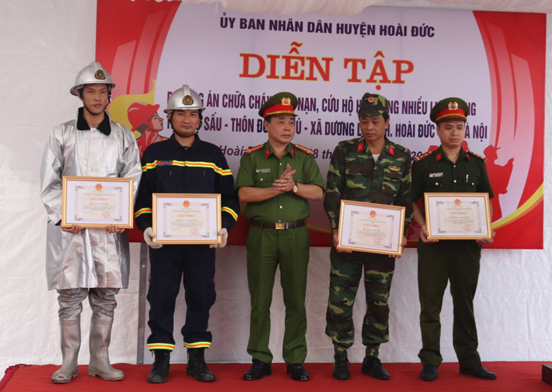 Thượng tá Nguyễn Ngọc Mẽ, Trưởng CAH Hoài Đức trao khen thưởng cho tập thể và cá nhân có thành tích trong nhiệm vụ diễn tập PCCC và CNCH