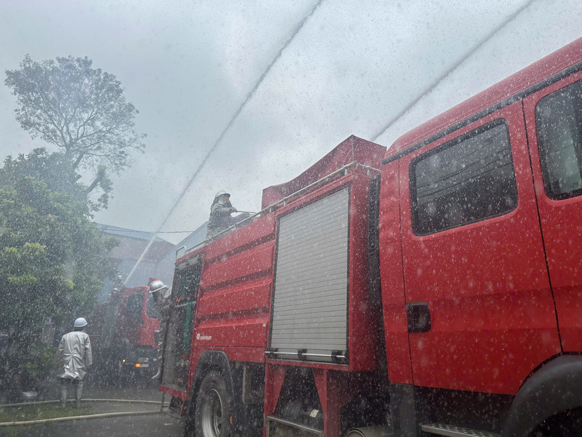 Cán bộ, chiến sĩ triển khai lăng giá chữa cháy phun nước vào đám cháy