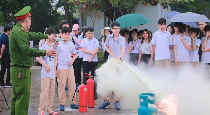 Các em học sinh tham gia thực hành dập tắt đám cháy