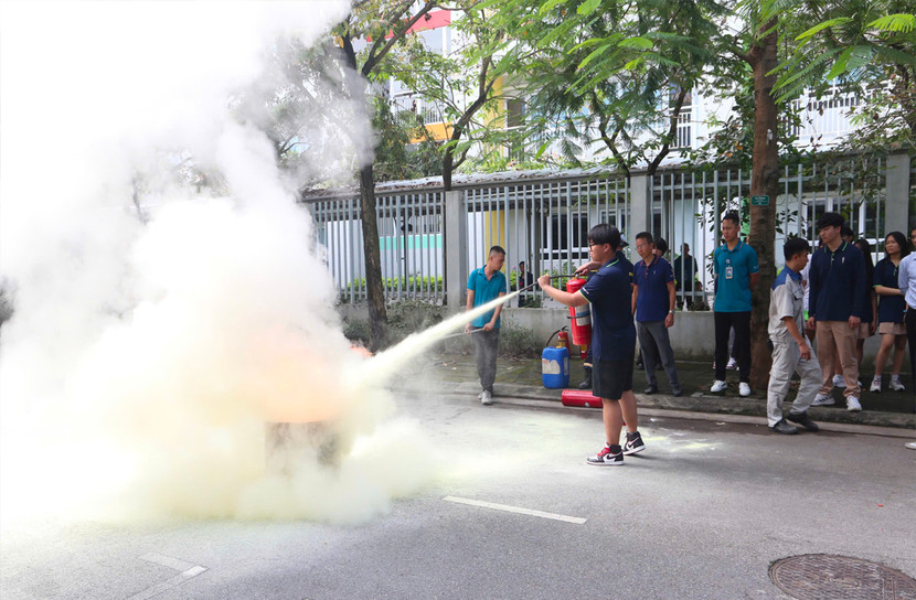 Học sinh và giáo viên nhà trường trải nghiệm thao tác sử dụng bình chữa cháy