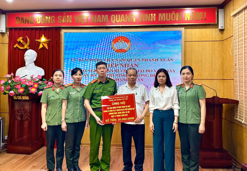 Đoàn công tác CAQ Tây Hồ trao tiền ủng hộ các nạn nhân trong vụ cháy