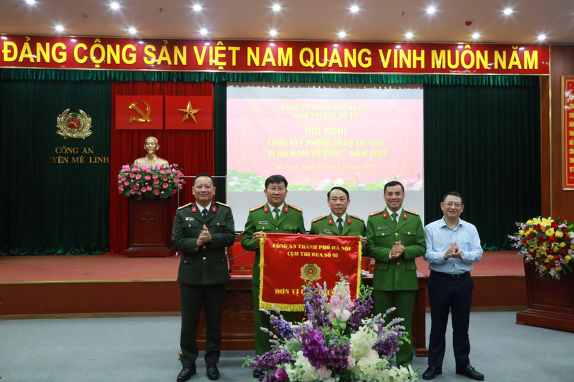 Đại tá Phạm Thanh Hùng và ông Hoàng Anh Tuấn, Chủ tịch UBND huyện Mê Linh chứng kiến Lễ trao Cờ đon vị Cụm trưởng cho CAH Gia Lâm và CAH Thanh Trì - đơn vị Cụm phó năm 2024