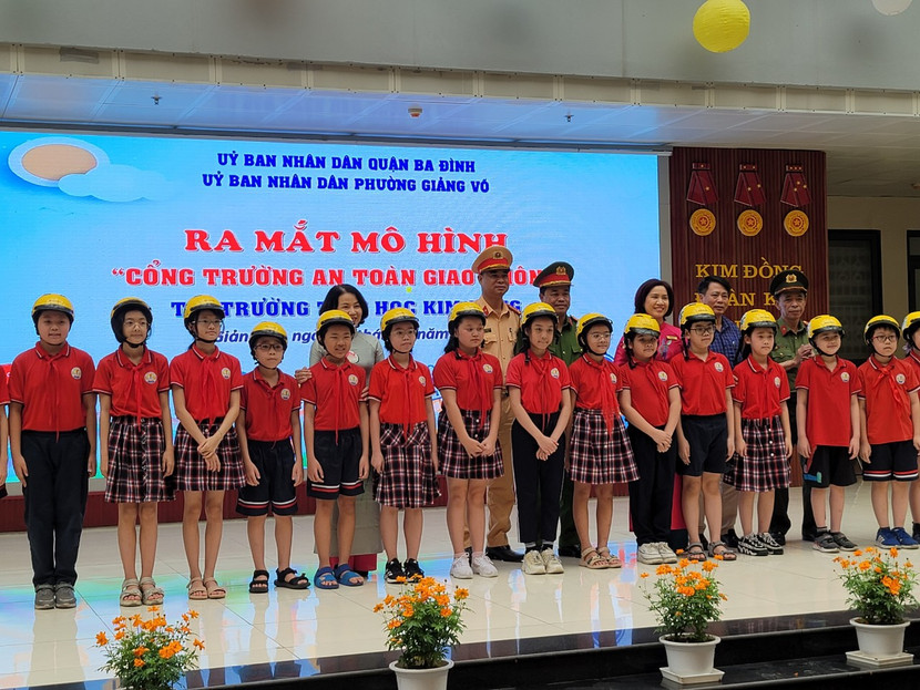Đại diện Phòng CSGT và CAQ Ba Đình trao mũ bảo hiểm cho học sinh Trường tiểu học Kim Đồng
