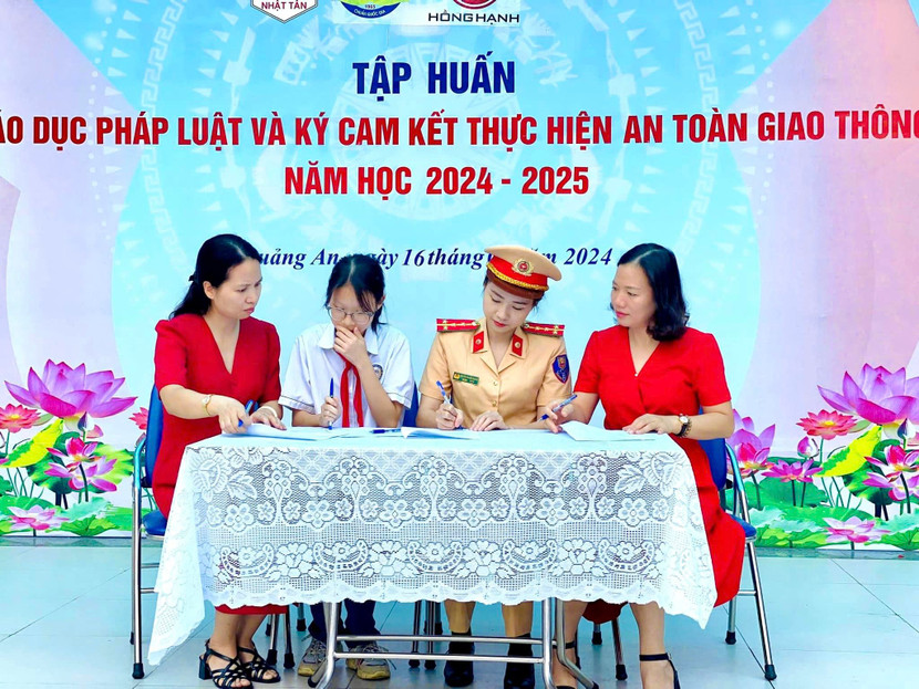 Lực lượng Công an cùng thày và trò trường THCS Quảng An ký cam kết chấp hành Luật an toàn giao thông