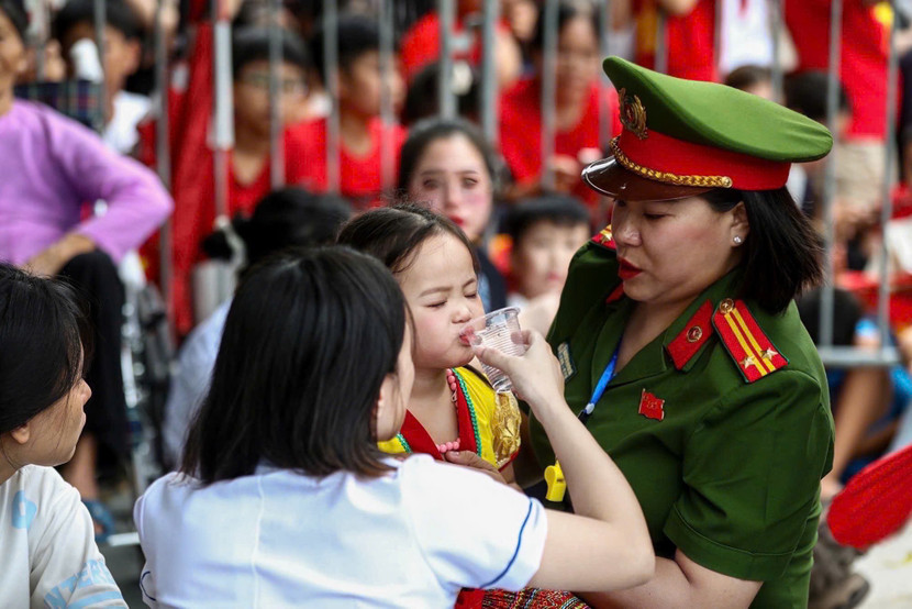 Nữ chiến sỹ Công an phường Tây Hồ cùng lực lượng y tế hỗ trợ cháu bé bị ngạt thở trong đám đông tại buổi sơ duyệt sự kiện A80