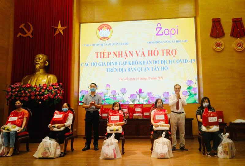 Đại diện lãnh đạo UB MTTQ Việt Nam quận Tây Hồ và đại diện Công ty Cổ phần Công nghệ Zapi trao tặng các phần quà đến các gia đình có hoàn cảnh khó khăn do đại dịch