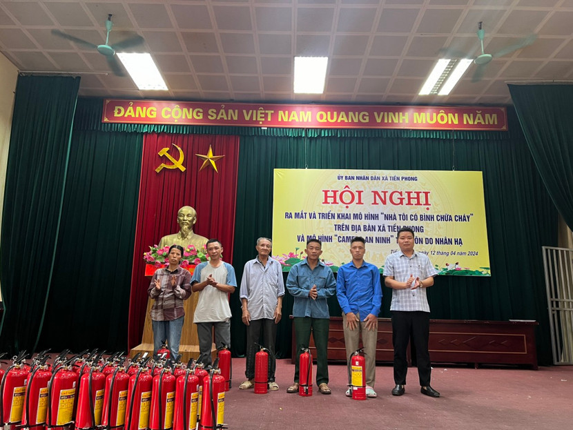 Ông Ngô Văn Trung, Chủ tịch xã Tiền Phong trao tặng bình chữa cháy cho người dân trên địa bàn