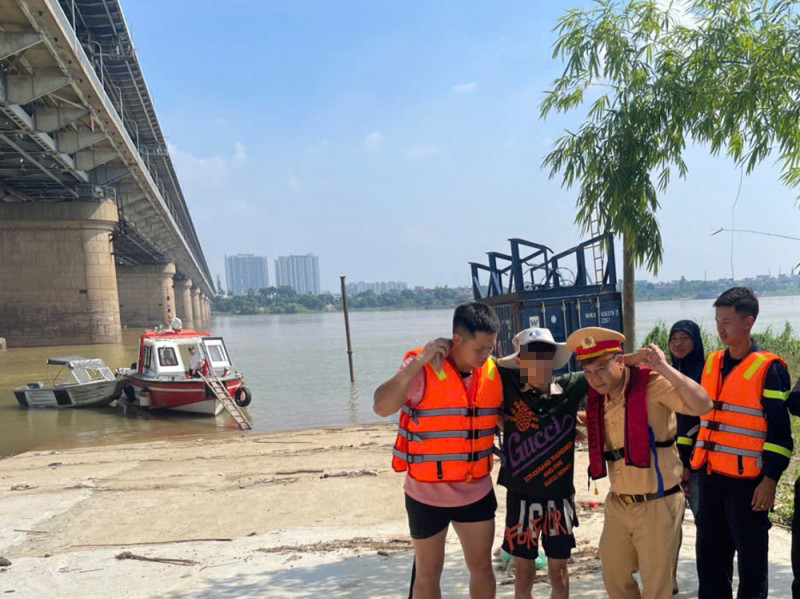 Lực lượng chức năng phối hợp đưa nam thanh niên lên bờ an toàn