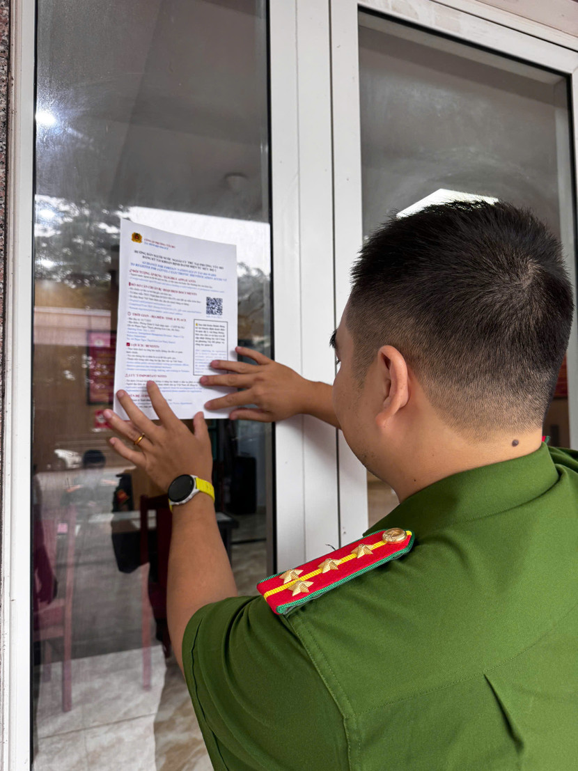 Công an phường Tây Hồ dán bảng thông tin song ngữ tuyên truyền, hướng dẫn người nước ngoài cư trú trên địa bàn đăng ký tài khoản định danh điện tử mức độ 2