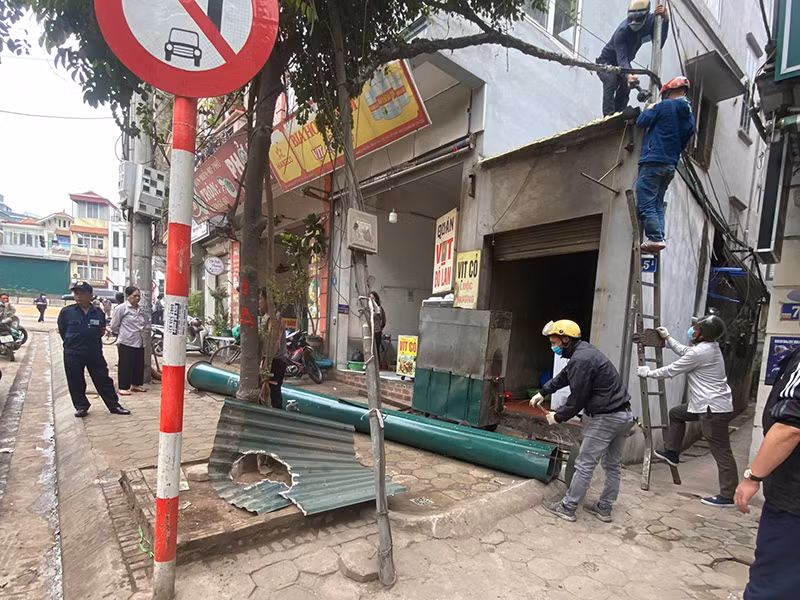 Với tinh thần kiên quyết, lực lượng chức năng phường Tứ Liên yêu cầu, vận động người dân tháo dỡ mái che, mái vẩy, biển quảng cáo gây mất mỹ quan đô thị