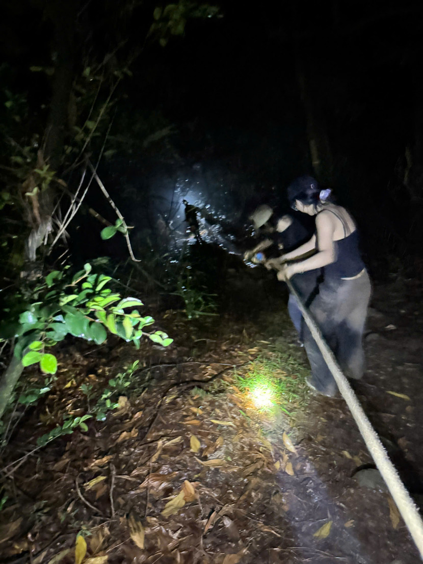 Lực lượng cứu nạn dùng dây chuyên dụng đưa nạn nhân trong đêm mưa từ trên núi xuống nơi an toàn