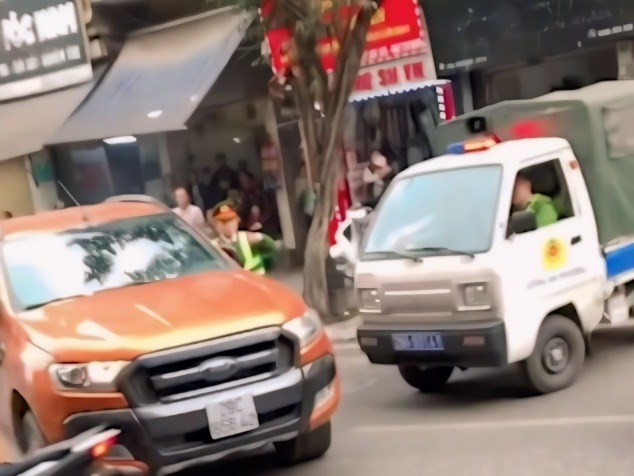 Khi bị Cảnh sát dừng xe kiếm tra, lái xe bán tải màu cam đã bất ngờ rồ ga bỏ chạy.