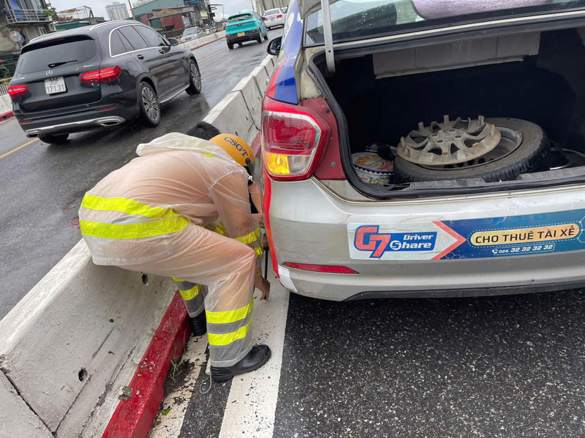 CSGT "đội mưa" thay lốp xe cho người dân trên cầu Chương Dương