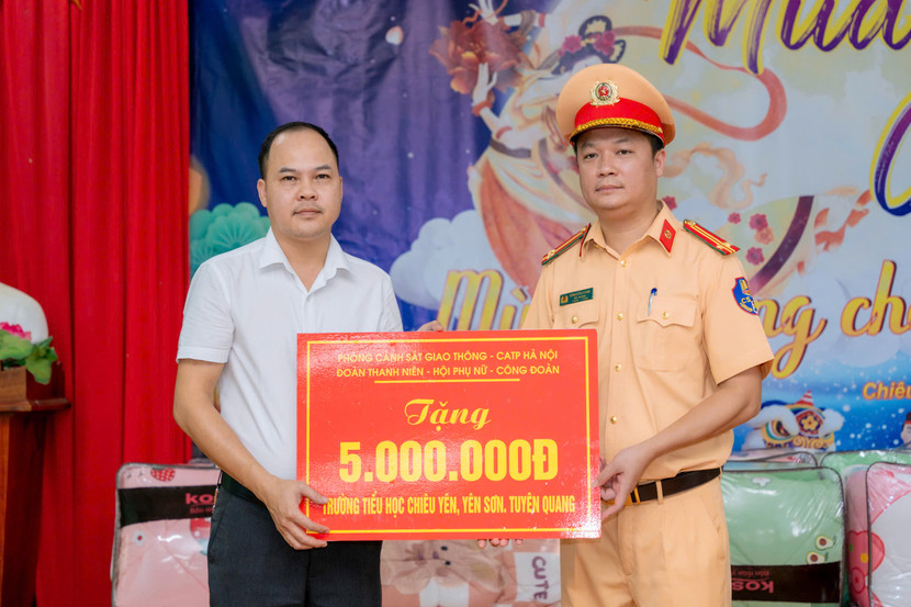 Trung tá Đặng Hồng Giang, Đội trưởng Đội CSGT số 3 trao quà cho trường Tiểu học Chiêu Yên.