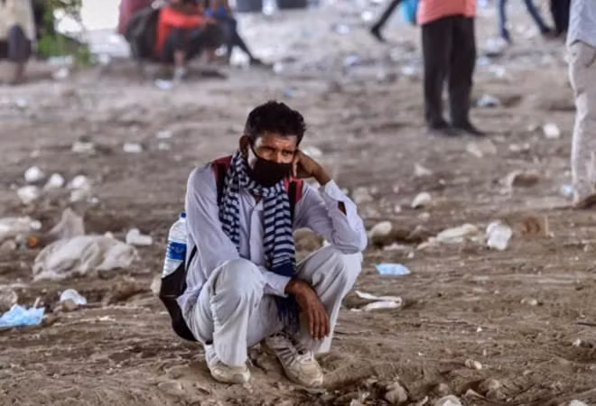 Người lao động vạ vật trên đường phố ở New Delhi chờ được phân phát thực phẩm Ảnh: Business Today