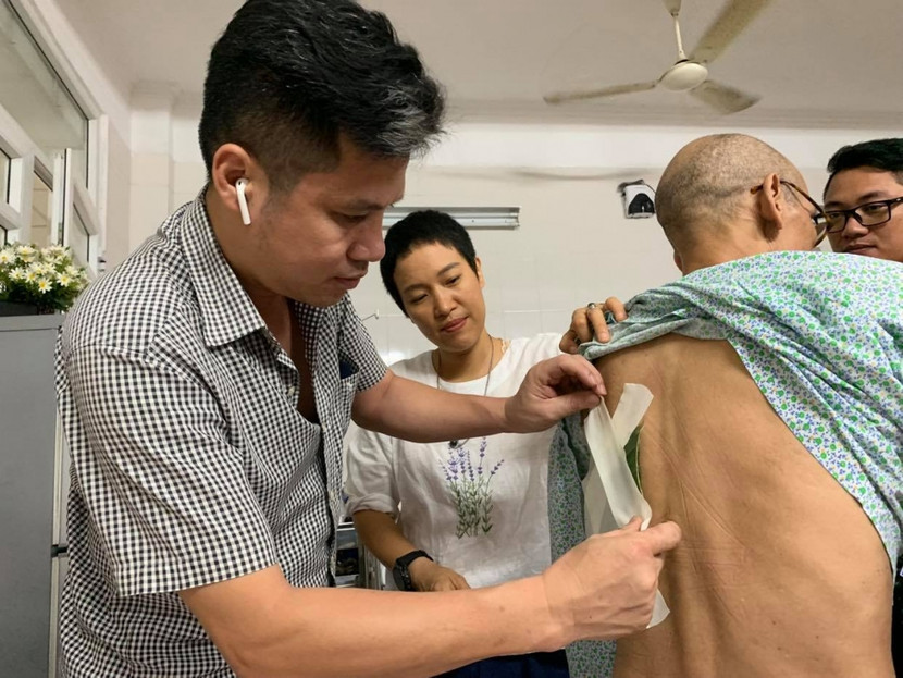 Thầy Nam dán thuốc cho bệnh nhân. Thầy Nam dán thuốc cho bệnh nhân.