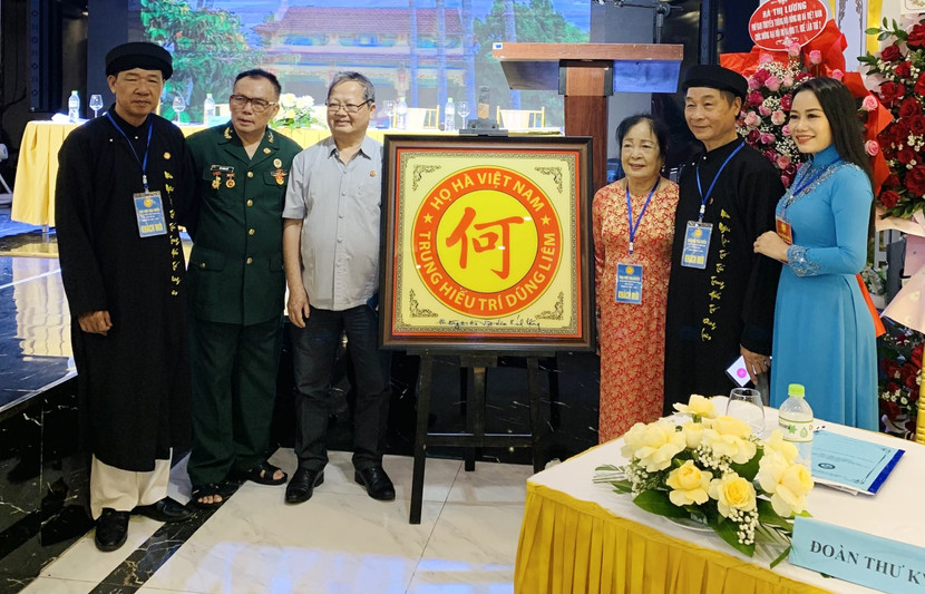 Ông Hà Quang Dự, Chủ tịch Hội đồng họ Hà Việt Nam (thứ từ trái sang), ông Hà Văn Sỹ, Phó Chủ tịch kiêm Tổng thư ký Hội đồng họ Hà Việt Nam (thứ 2 từ phải sang) và một số đại biểu bên logo họ Hà Việt Nam, với 5 chữ "Trung - Hiếu - Trí - Dũng - Liêm" Ông Hà Quang Dự, Chủ tịch Hội đồng họ Hà Việt Nam (thứ từ trái sang), ông Hà Văn Sỹ, Phó Chủ tịch kiêm Tổng thư ký Hội đồng họ Hà Việt Nam (thứ 2 từ phải sang) và một số đại biểu bên logo họ Hà Việt Nam, với 5 chữ "Trung - Hiếu - Trí - Dũng - Liêm"