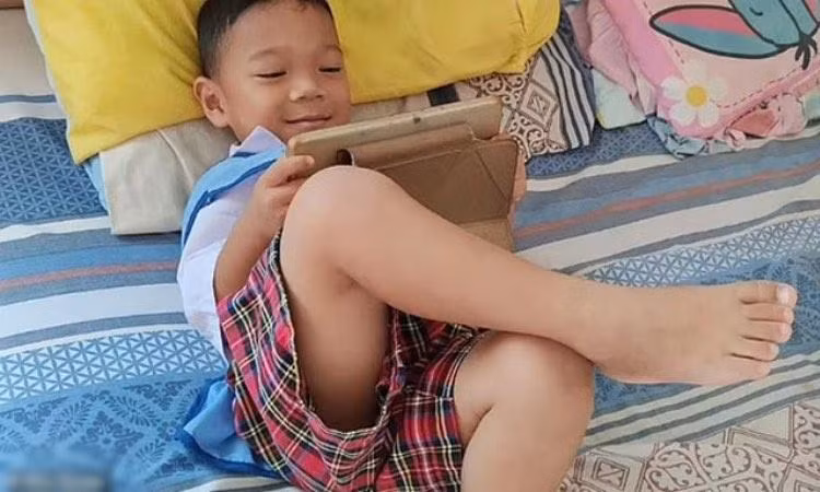 Bé Sumaee sử dụng máy tính bảng trước khi bị tấn công ở nhà trẻ ở Thái Lan. Ảnh: Sky News.