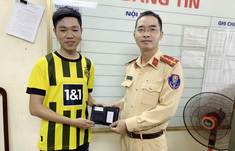 Đại úy Trần Doãn Tuyên trao trả chiếc ví cho anh Đỗ Hữu Nghĩa.