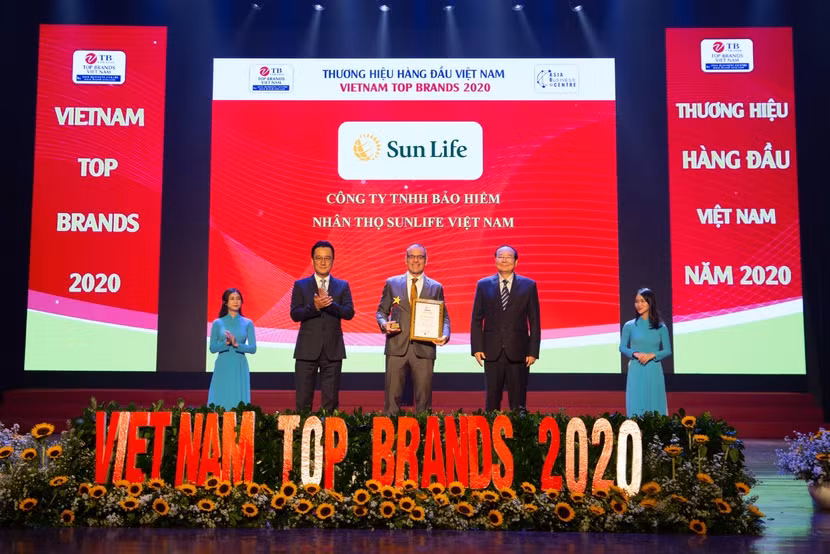 Ông Larry Madge Tổng giám đốc Sun Life Việt Nam (đứng giữa) nhận danh hiệu Top 10 Thương hiệu hàng đầu Việt Nam