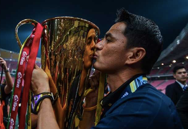 HLV Kiatisak cùng chiếc cúp vô địch AFF sau khi giúp Thái Lan thắng Malaysia tổng tỉ số 4-3 tại chung kết năm 2014