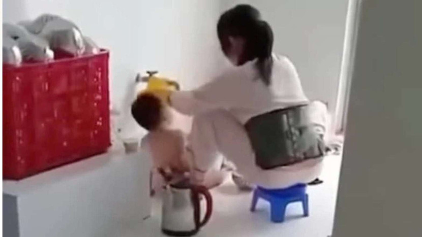 Cô giáo mầm mon nhồi nhét thức ăn vào miệng trẻ.