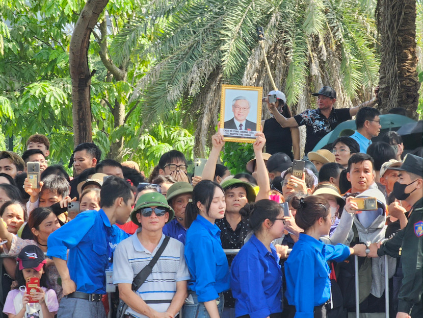 Bất chấp nắng nóng, người dân đứng sát nhau, mắt hướng về Nghĩa trang Mai Dịch